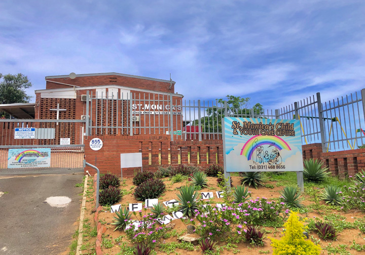 The exterior of a children's home featuring the name sign with a rainbow on it. 