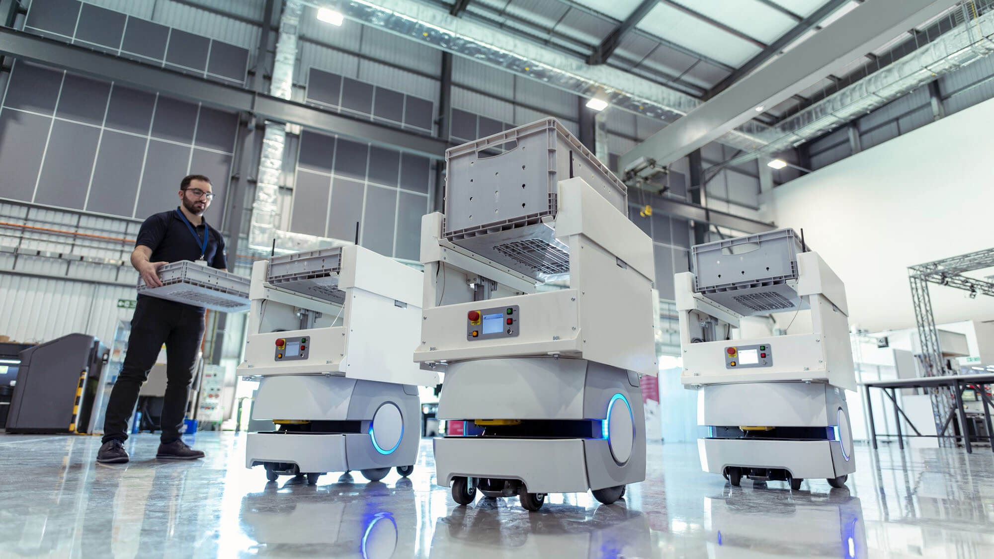 Worker with factory storage robots in warehouse storage research factory